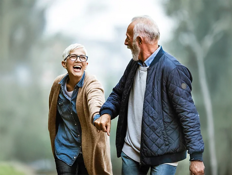 Elderly couple walking outdoors smiling together